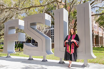 Photo of a graduate student posing next to a FSU sign. Links to Gifts of Appreciated Securities