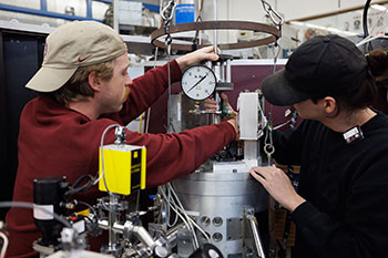 Photo of students working on a machine. Links to Gifts of Cash, Checks, and Credit Cards